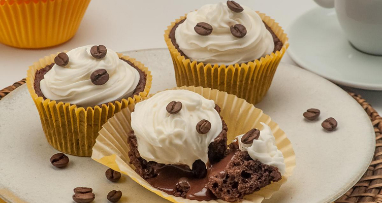 Imagem de um cupcake com um graos de cafe e um chantilly